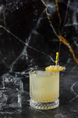 Alkolik viski, viski, limon, bal şurubu ve şekerli zencefilli kokteyl. Siyah arkaplanda kokteyl camı.