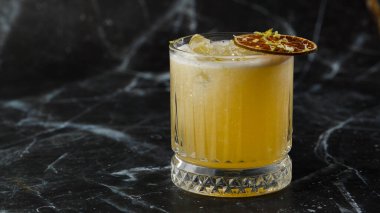 Meyve karışımı, mezcal ve kuru limonlu, siyah mermer arka planda. Sıcak renkli kokteyller. Mezcal kokteyli