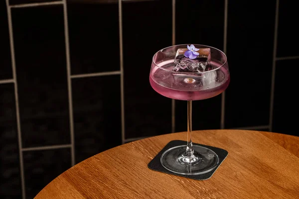 Aviation, drink with gin, lemon juice,maraschino liqueur and violet cream liqueur standing on bar counter.