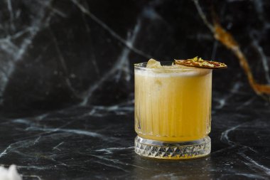 Meyve karışımı, mezcal ve kuru limonlu, siyah mermer arka planda. Sıcak renkli kokteyller. Mezcal kokteyli