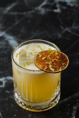 Meyve karışımı, mezcal ve kuru limonlu, siyah mermer arka planda. Sıcak renkli kokteyller. Mezcal kokteyli