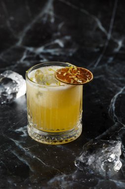 Meyve karışımı, mezcal ve kuru limonlu, siyah mermer arka planda. Sıcak renkli kokteyller. Mezcal kokteyli