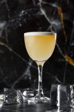 Pisco kokteyli - limonlu viski, yumurta beyazı, koyu bulanık arka planda şekerli şurup. Metin için boşluk.