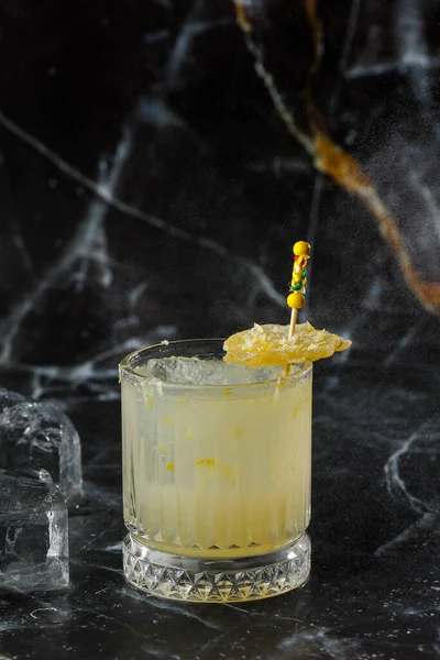 Alkolik viski, viski, limon, bal şurubu ve şekerli zencefilli kokteyl. Siyah arkaplanda kokteyl camı.