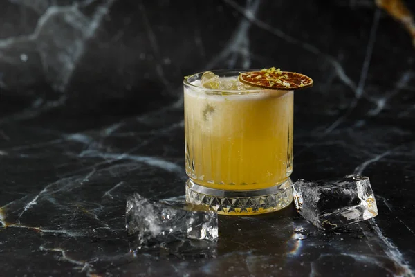 Meyve karışımı, mezcal ve kuru limonlu, siyah mermer arka planda. Sıcak renkli kokteyller. Mezcal kokteyli