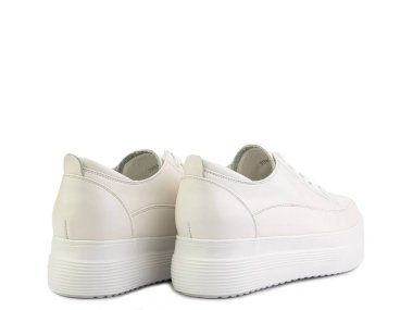 Beyaz klasik deri ayakkabılar. Sıradan kadın tarzı. Beyaz bağcıklı ve beyaz lastik tabanlı. Beyaz arka planda izole edilmiş yakın çekim. Arka manzara. Moda ayakkabıları..