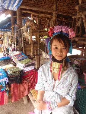 CHIANG MAI, THAILAND - JUNE 2012: Unidentified girl from long neck Karen tribe sells souvenirs on June 2012 in Chiang Mai. Many Karen tribes fled to Thailand due to conflict with the regime in Burma. clipart