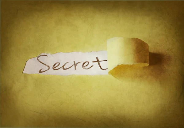 Word secret written under torn strip of paper — Stock Photo, Image