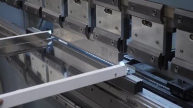 Metal bükme makinesi. Endüstriyel bükme makinesinin çelik işçilerinin elleri. Metal pres endüstrisi ekipman fabrikası. İşçi çelik levha tutar bükme makinesi çelik ürünler oluşturur. Metal Çalışması