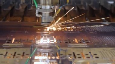 Otomatik makine CNC lazer kesici metal plaka. Modern metal lazer levha çelik levha kesiyor. Yüksek hassasiyetli kesim makinesi metal parçası. Yanık lazer kesici çelik ürünlerinde çalışıyor. Metal işçiliği