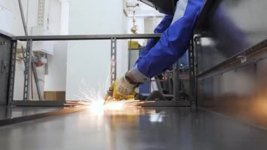 İşçi kaynak yapan metal plaka. Kaynakçı kaynak makinesi metal işçilerinin çelik ürünlerini kıvılcımlandırıyor. Zanaatkar kaynak yapan çelik çerçeve inşaat fabrikasına kıvılcım saçıyor. El işçiliği. Demir işçiliği.