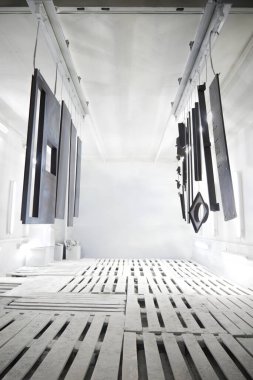 Boyama odasındaki fabrika metal yüzey boyası. Sprey kabinde metal parçaların toz kaplaması. Boya kabininde metal ürünler boyama endüstrisi. Çelik parçaları Endüstri içinde boya garajı