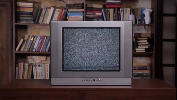 Old books background retro television set. Bad television signal noise. Room old tv set. 90s retro tv screen static noise. Analog static effect retro tv room interior home library bookshelf background — Stock Video