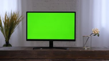 Akıllı TV monitörü yeşil ekran. Çağdaş oturma odası televizyonu yeşil krom anahtar televizyon seti 2000 'ler. LCD TV evde televizyon izliyor. Yatak odasının içinde düz ekran televizyon