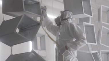 Metal ürünlerin toz tabakası. Endüstriyel boya, metal tozu kaplama boya üretim süreci. Parça parça metal atölyesini sprey tabancayla boyayan kapak çalışanı. Metal işçiliği fabrika boyası