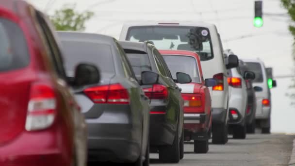 Bulvar trafiği trafiği yeşil ışıkta arabaları hareket ettiriyor. Yeşil ışık yolu trafiği otobandaki yoğun otoyol araçlarını yavaşça hareket ettiriyor. Birçok araba yavaş yol trafiği sıkışıklığı — Stok video