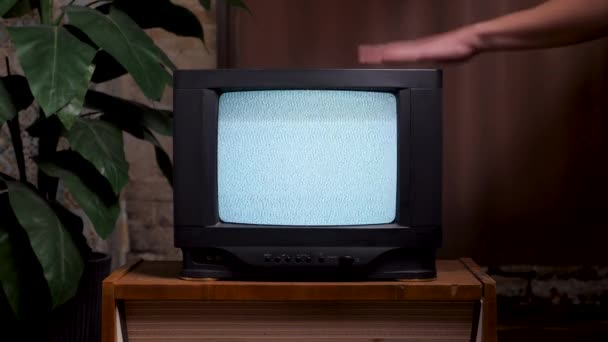 Adam eski TV ekranına vuruyor. 80 'lerin ev içi eski televizyon seti. Kötü televizyon sinyali gürültüsü. Ekranda dönen hiçbir sinyal televizyonu retro statik gürültüye vuramaz. Analog statik efekt retro TV — Stok video