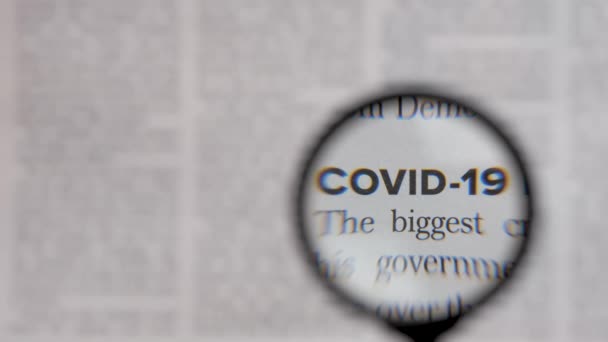 Health news text covid 19 newsletter through lens magnifying loupe. Read newspaper article headline covid news letter. Newspaper headline news coronavirus pandemic information search magnifier glass — Stock Video