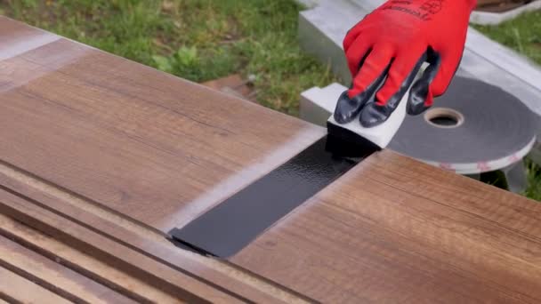 Hantverk trä lim applicera skyddsgolv på trägolv. Laminatgolv bygglim sätta på plankor av trä däck. Reparation hem konstruktion golvbrädor — Stockvideo