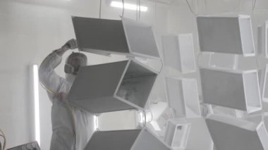 Metal ürünlerin toz tabakası. Endüstriyel boya, metal tozu kaplama boya üretim süreci. Parça parça metal atölyesini sprey tabancayla boyayan kapak çalışanı. Metal işçiliği fabrika boyası