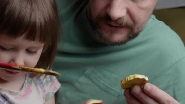 Aile babası ve çocuk yaratıcı zamanlarını resmeden kız çocuk resim sanatları eğitimi alıyor. Boyacı kız çiziyor. Baba ve kızı birlikte resim yapıyorlar. El çizimi çocuk oyuncağı.