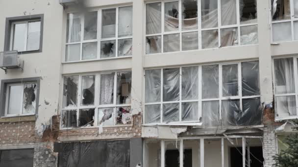 Після цього в Україні цивільні обстрілюють будинок вибуховим склом. Скляне скло руйнує Україну від військових руйнувань. Розбите скло руйнує будинок з вікна будівлі. — стокове відео