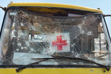 Otobüsü boşaltırken kurşun deliği kurşun yarası ön cam kırılması ikon kırmızı haç işareti insani logo. 2022 Savaş Rusya Ukrayna savaş suçlarını işgal etti. Mark kurşun otomobil kazası yok edildi.