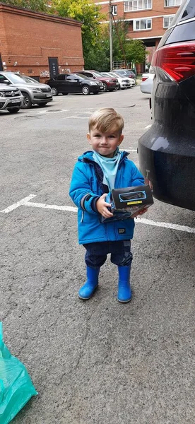 Happy Little Boy Todler in rubber laarzen en jas met korst in de hand — Stockfoto