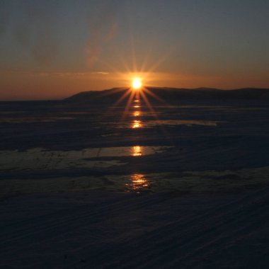 Şafak Baykal Gölü. Kış, buz, güneş ışınları.