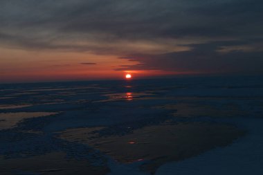 Kışın Baykal Gölü 'nde şafak vakti. Güneş, gökyüzü, buz. Listvyanka köyü yakınlarında güneş gözlemevi