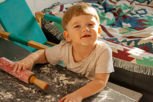 Cute happy todler boy baking cookies in the kitchen flour rolling pin dough — Fotografia de Stock