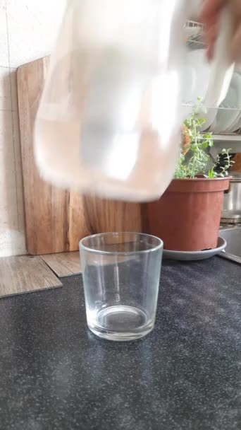 Vídeo vertical vaso de agua verter agua del filtro en un plato transparente. Medecina. Buenos hábitos. — Vídeo de stock