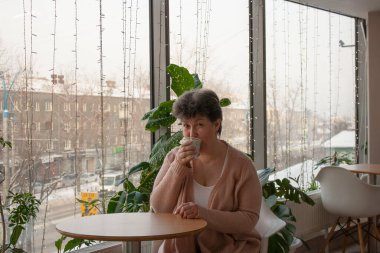 Tatlı Leydi 60 yıl boyunca bir kafede kahve içerek Herald Cozy kışının arka planında