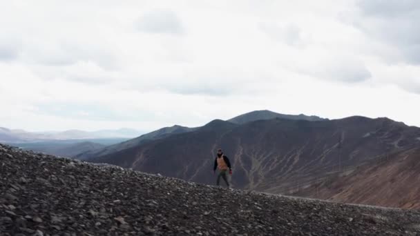 계곡 과산을 배경으로 산을 타고 걷는 여행자의 모습 — 비디오