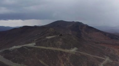 Bulutların arka planına karşı dağın havadan görünüşü ve bir dağ sırası