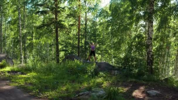 Девушка занимается фитнесом в лесу — стоковое видео