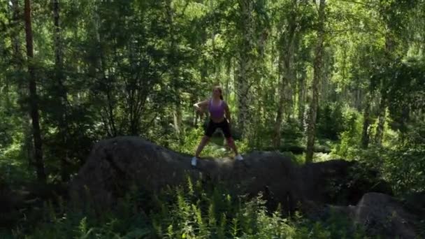 Девушка занимается фитнесом в лесу — стоковое видео