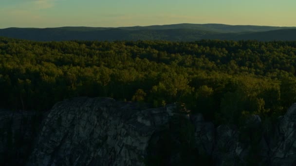 Vue aérienne d'une fille méditant sur un rocher au coucher du soleil — Video