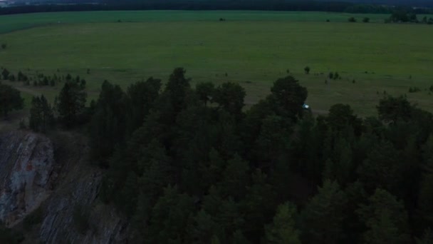 Aerial view of a car driving in nature on a field at sunset — Stockvideo