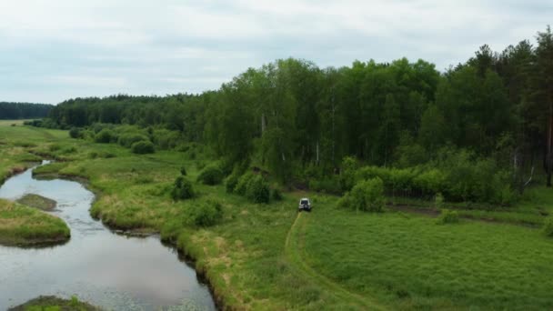 Vista aérea de un coche conduciendo en la naturaleza cerca del río — Vídeo de stock