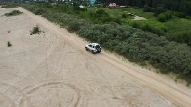 Vista aérea de um carro dirigindo na areia — Vídeo de Stock