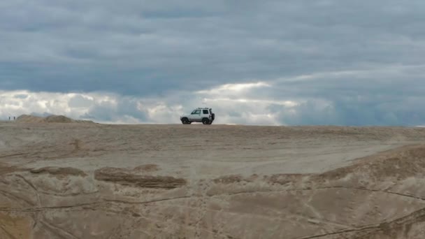 Vista aérea de um carro dirigindo na areia — Vídeo de Stock