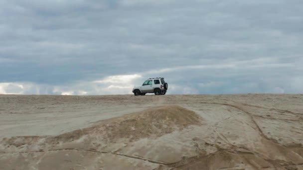 Vista aérea de um carro dirigindo na areia — Vídeo de Stock