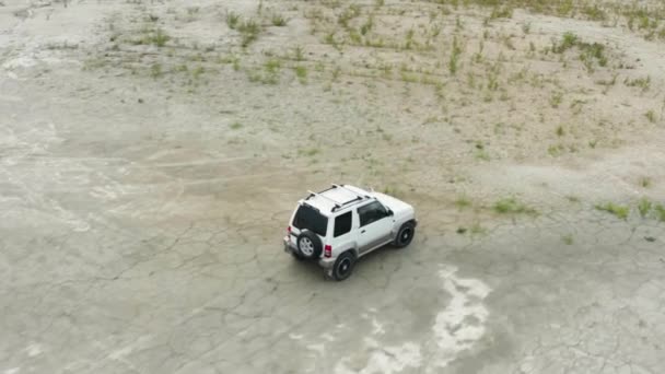 Vista aérea de un coche conduciendo sobre arena — Vídeo de stock