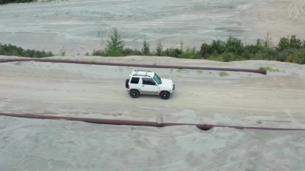 Vista aérea de un coche conduciendo sobre arena — Vídeo de stock