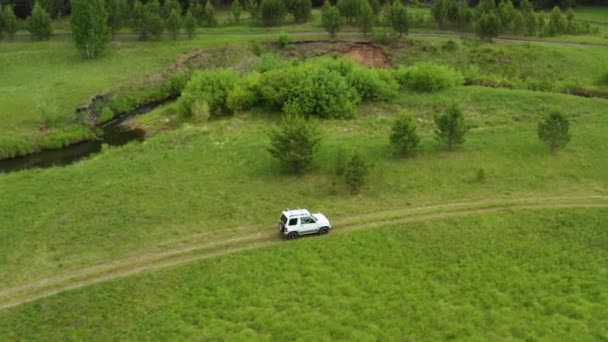 Вид зверху на джип, що їде по ґрунтовій дорозі в природі — стокове відео