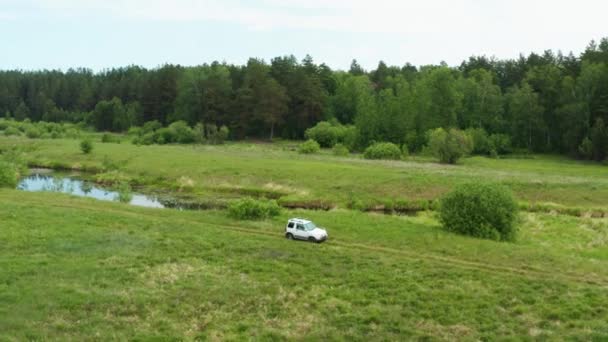 Vista aérea de un coche conduciendo en la naturaleza cerca del río — Vídeo de stock