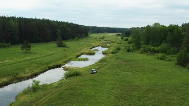Vista aérea de un coche conduciendo en la naturaleza cerca del río — Vídeos de Stock