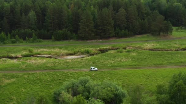 Veduta aerea di una macchina che guida nella natura vicino al fiume — Video Stock
