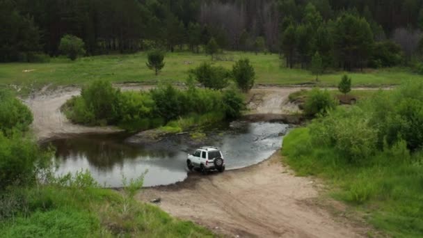 Flygfoto över en jeep som kör över floden — Stockvideo